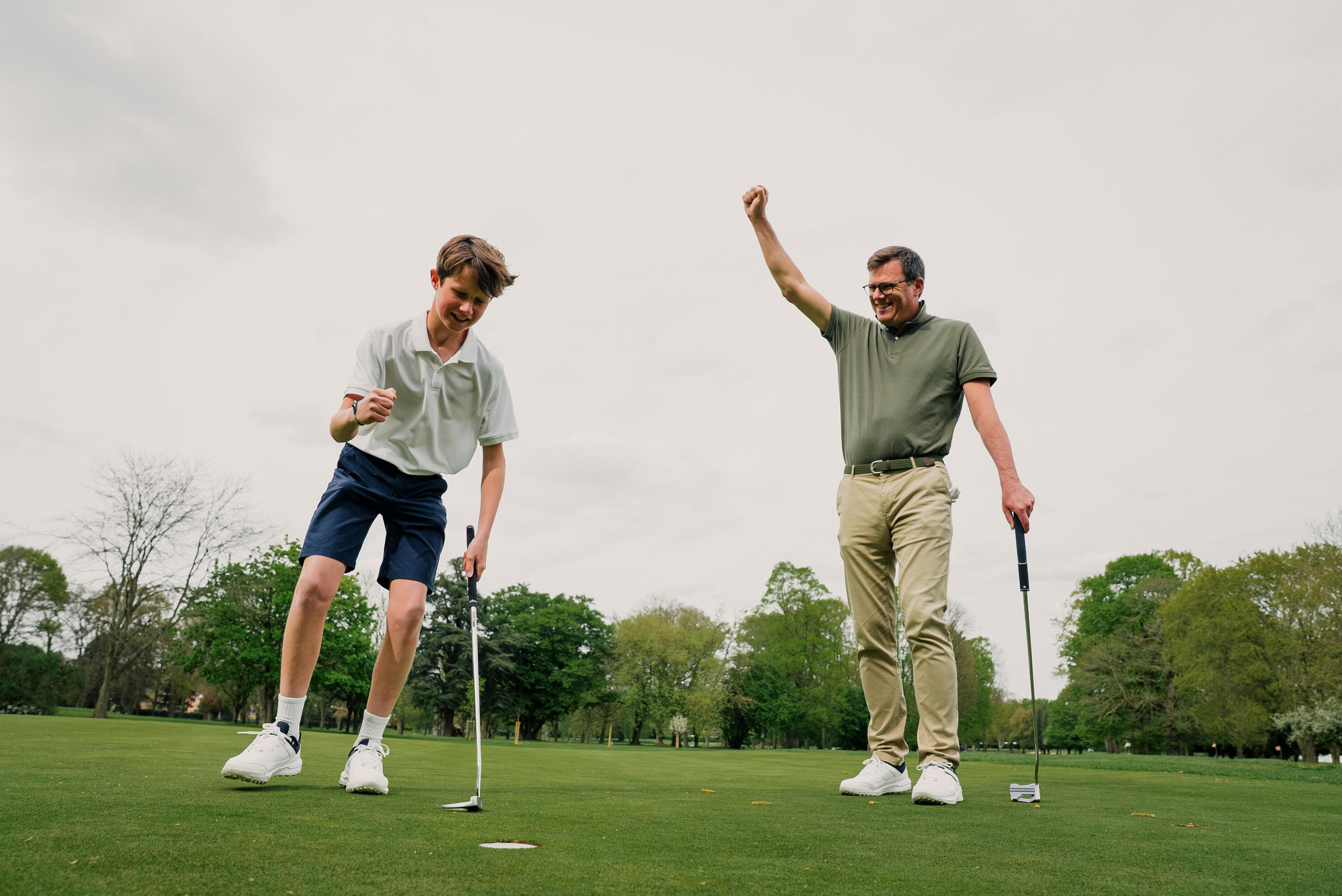 Jugadores de golf festejando un hoyo en una cancha de césped