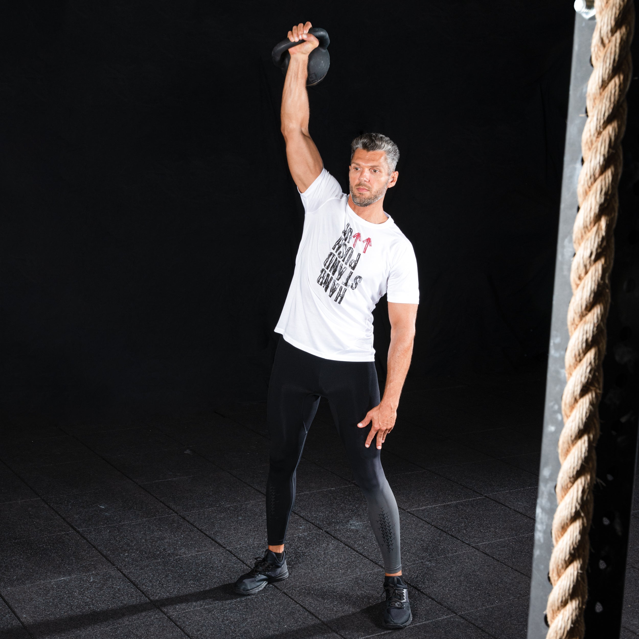 Atleta levantando una barra con discos en un box de crosstraining usando accesorios de protección