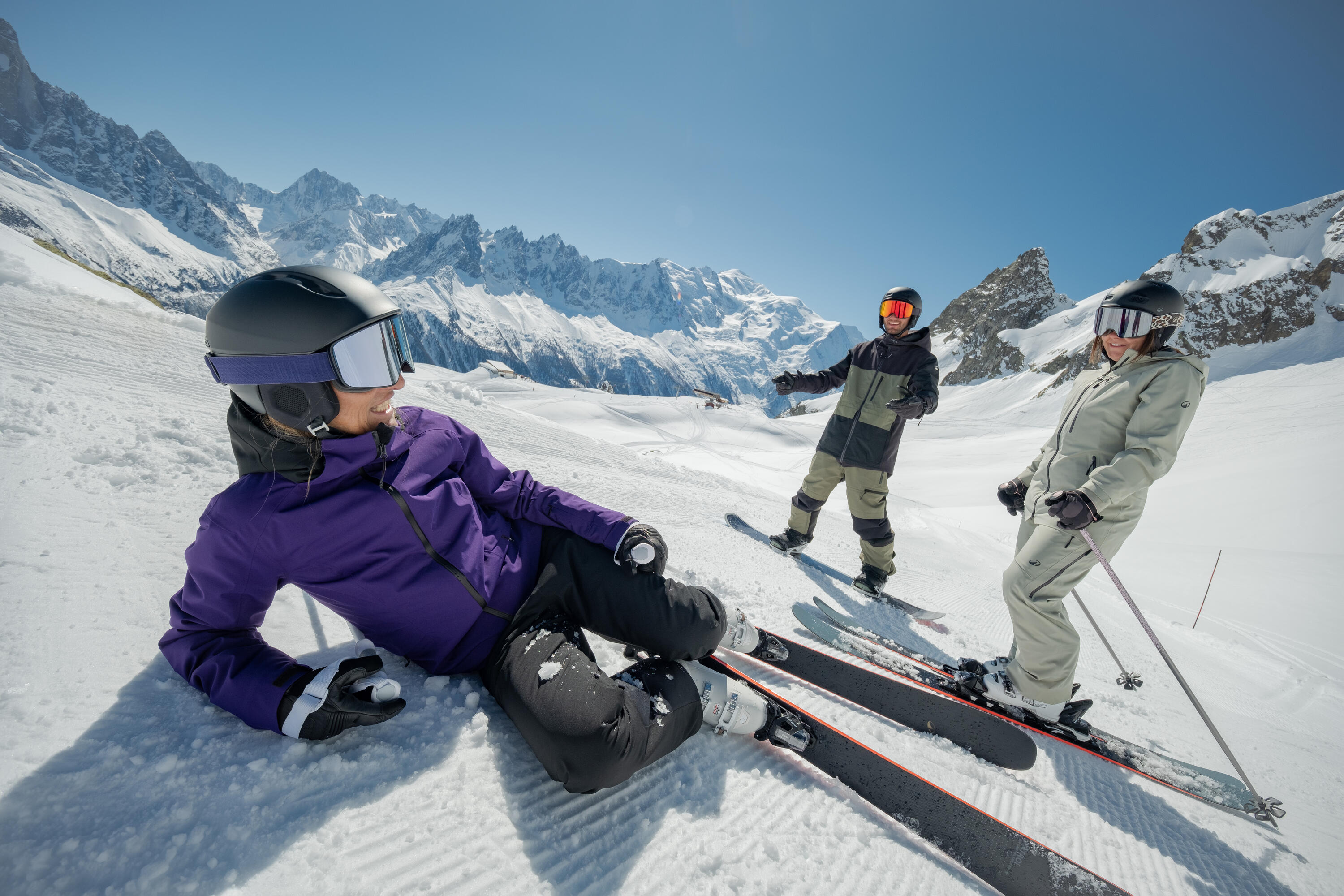 Persona esquiando en una montaña nevada con indumentaria técnica, campera de abrigo y casco de protección